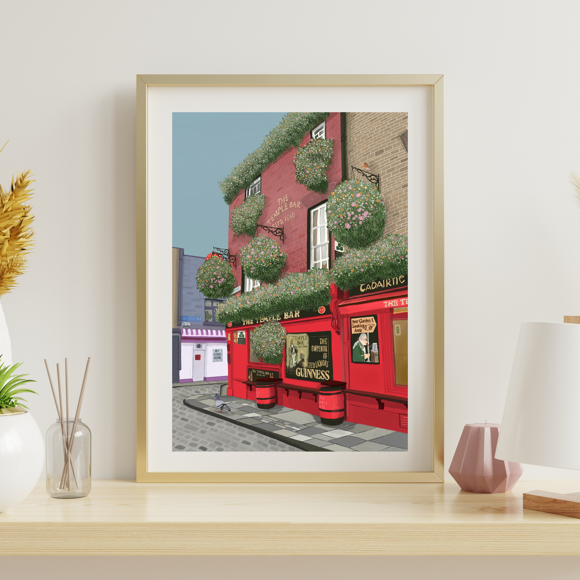 Hand-illustrated fine art print of Temple Bar, Dublin displayed in a light oak frame in a bright, modern living room.