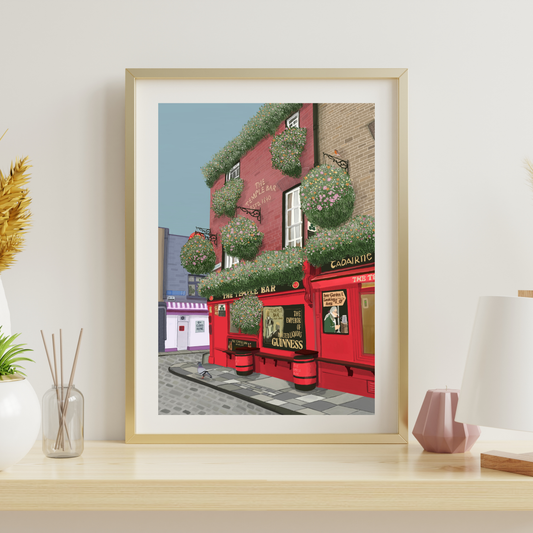 Hand-illustrated fine art print of Temple Bar, Dublin displayed in a light oak frame in a bright, modern living room.